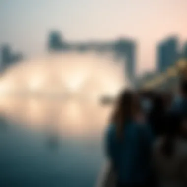 Visitors Captivated at the Waterfront Visitors gathered at the waterfront, captivated by the mesmerizing Dubai Fountain show, with reflections on the water